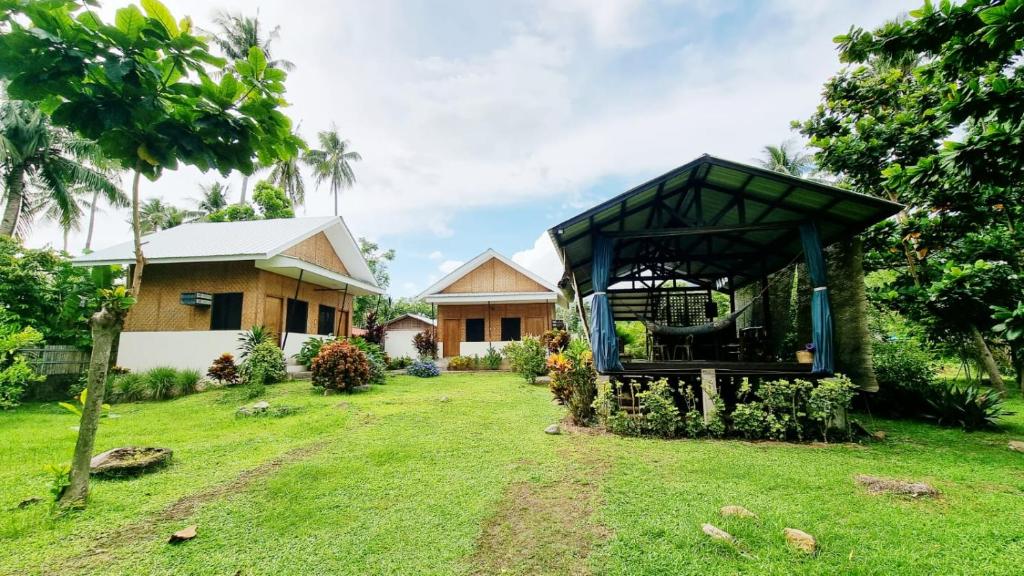 uma casa com um gazebo no quintal em Bahandi Beach Lodge em Mambajao