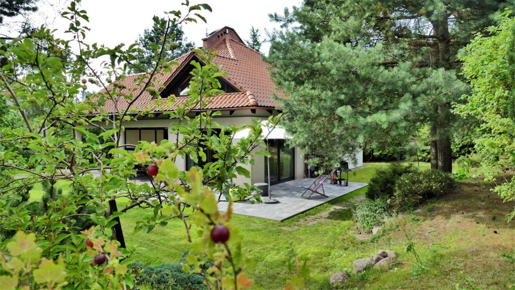 una casa con jardín en medio de un patio en DOBRE MIEJSCE – przytulny dom przy jeziorze Głębokim, en Borkowo