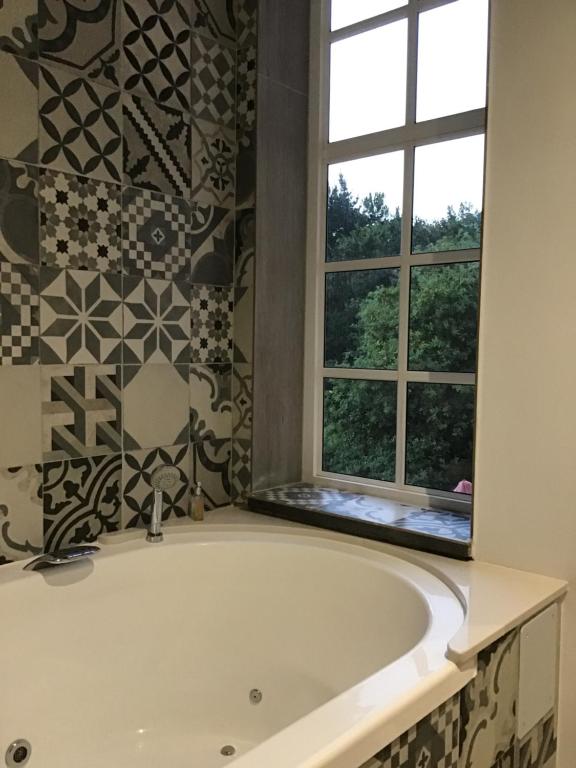a bath tub in a bathroom with a window at San Pedro in Pontevedra
