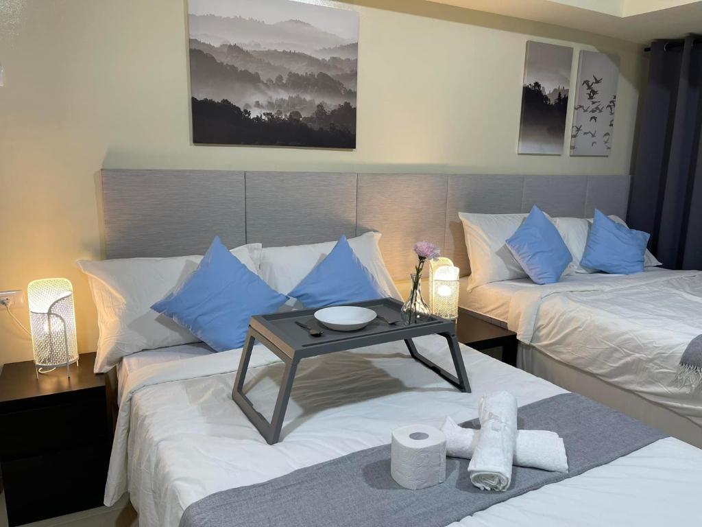 Habitación de hotel con 2 camas y almohadas azules en Serin Tagaytay Staycation, en Tagaytay