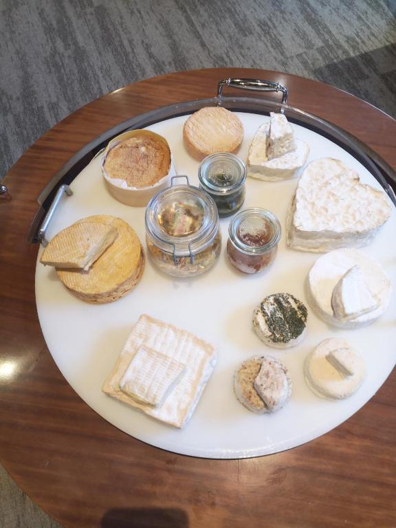 a plate of different types of bread on a table at Logis Hôtel-Restaurant Les Airelles in Neufchâtel-en-Bray