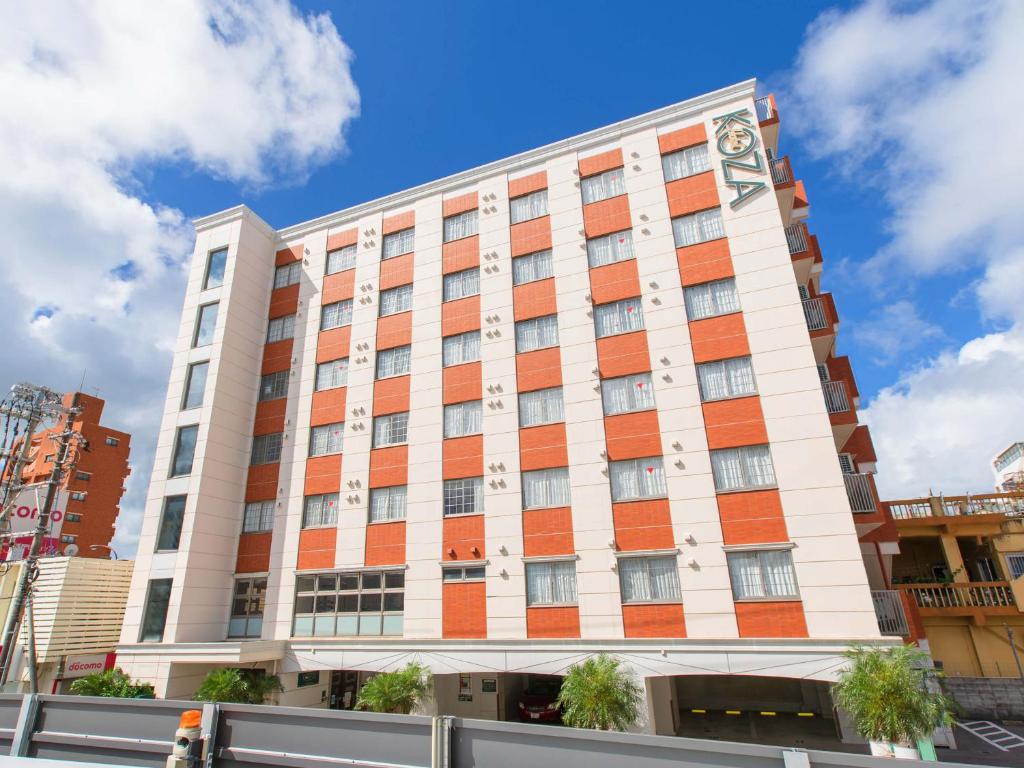 a tall building with orange and white at Hotel Koza in Okinawa City