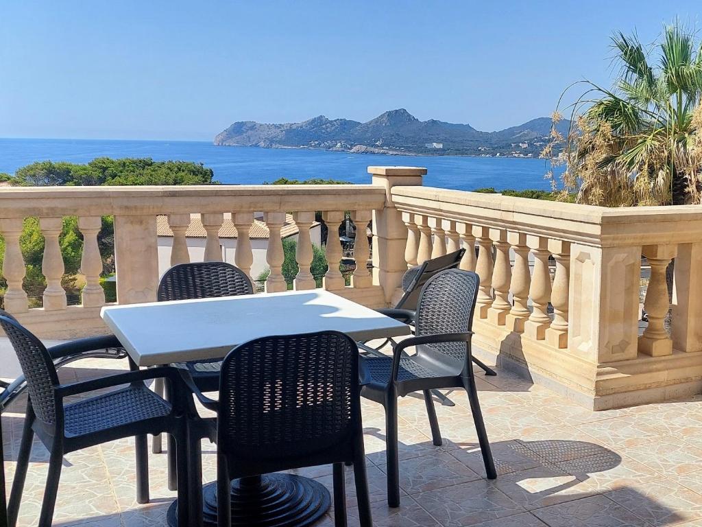 uma mesa e cadeiras numa varanda com o oceano em Sol y Mar em Cala Ratjada