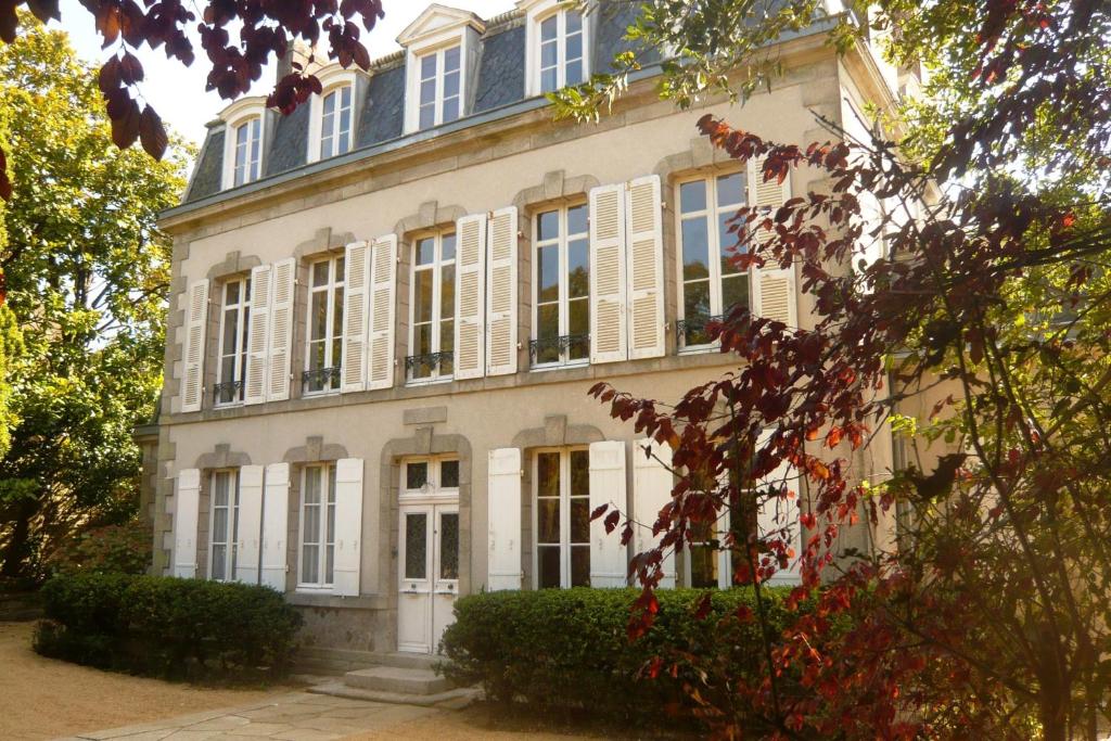 ein großes weißes Gebäude mit weißen Fensterläden in der Unterkunft Maison de la Garenne & Spa in Vannes