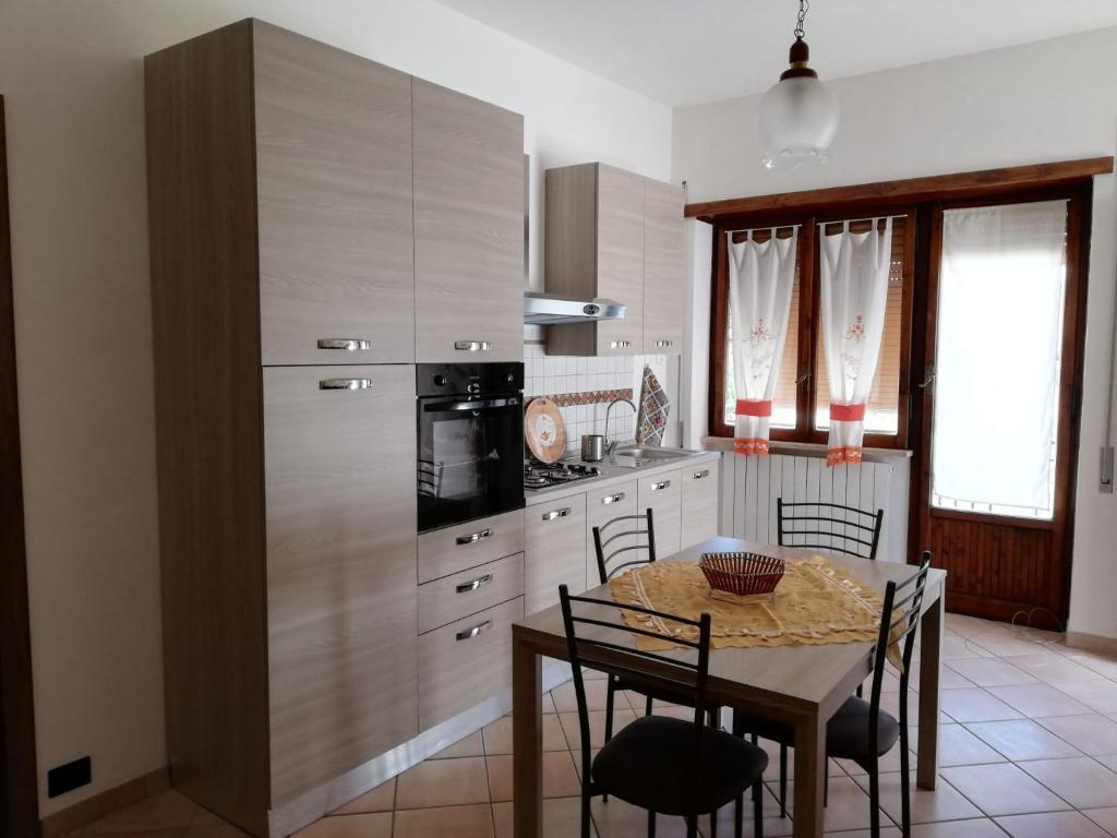 Appartamento Roma, في روما: مطبخ مع طاولة وثلاجة وطاولة وكراسي