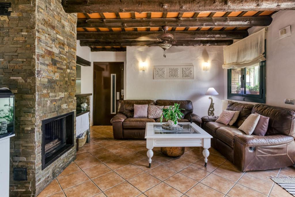 uma sala de estar com um sofá e uma lareira em El paller em Borrassá