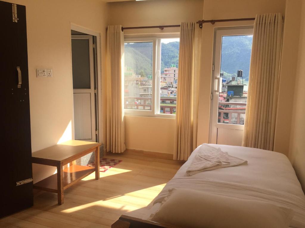 una camera da letto con un letto e una grande finestra di Beli Guest House a Pokhara