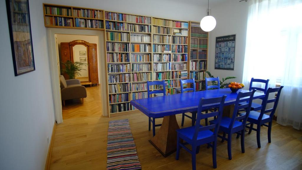 ein Esszimmer mit einem blauen Tisch und Stühlen in einer Bibliothek in der Unterkunft Meta Biblioteka in Puławy