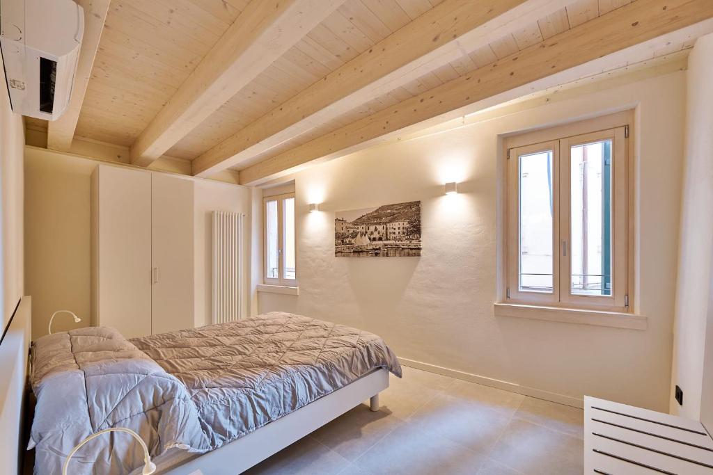 um quarto com uma cama e duas janelas em ApartmentsGarda - Residenza Mercanti em Garda