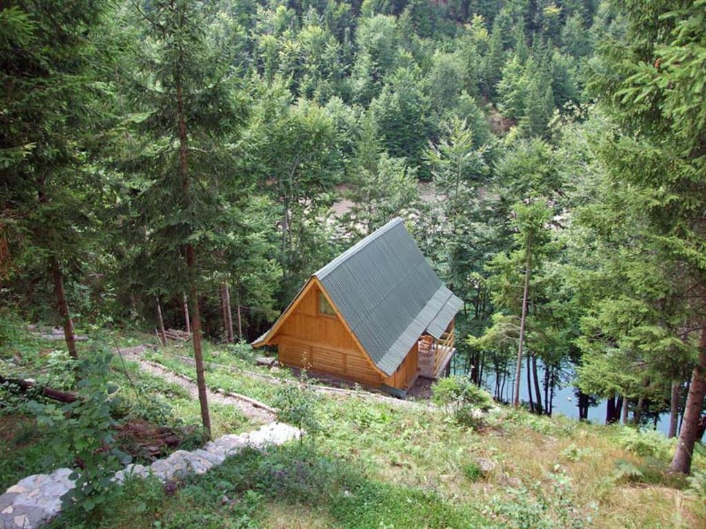 a wooden cabin in the middle of a forest at Little Heaven Apartments in Jezdići