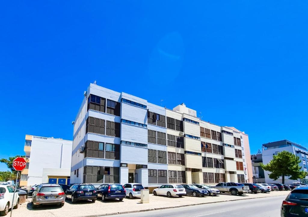 a parking lot with cars parked in front of a building at FLH Monte Gordo Summer Flat in Monte Gordo