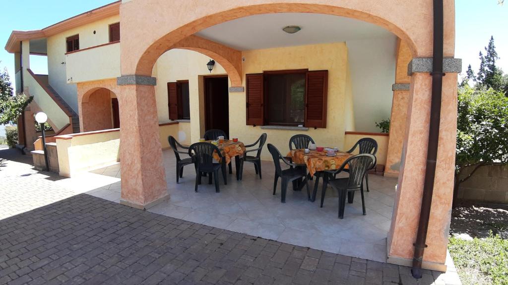 un patio al aire libre con mesa y sillas en Guesthouse Affittacamere Goloritzè, en Cala Gonone