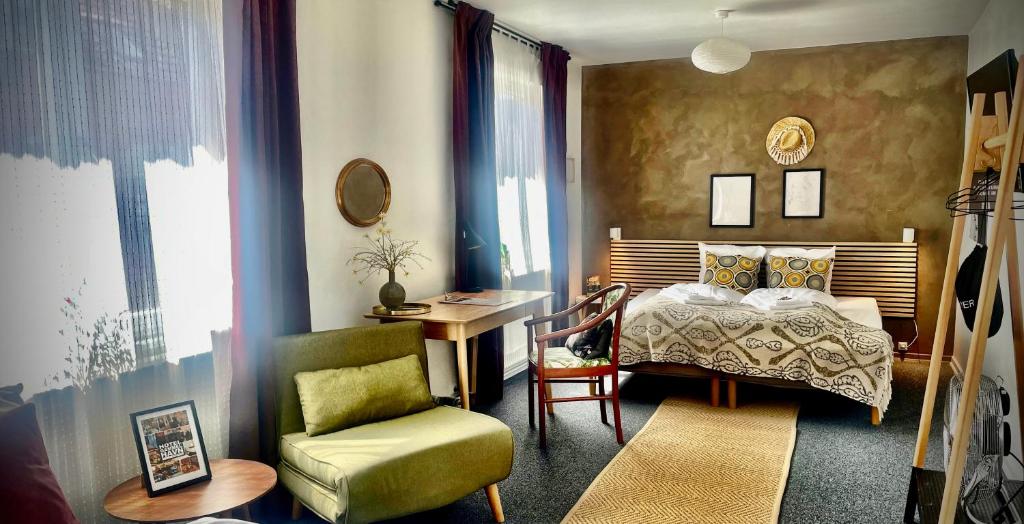 een slaapkamer met een bed, een stoel en een bureau bij Hotel Gammel Havn in Fredericia