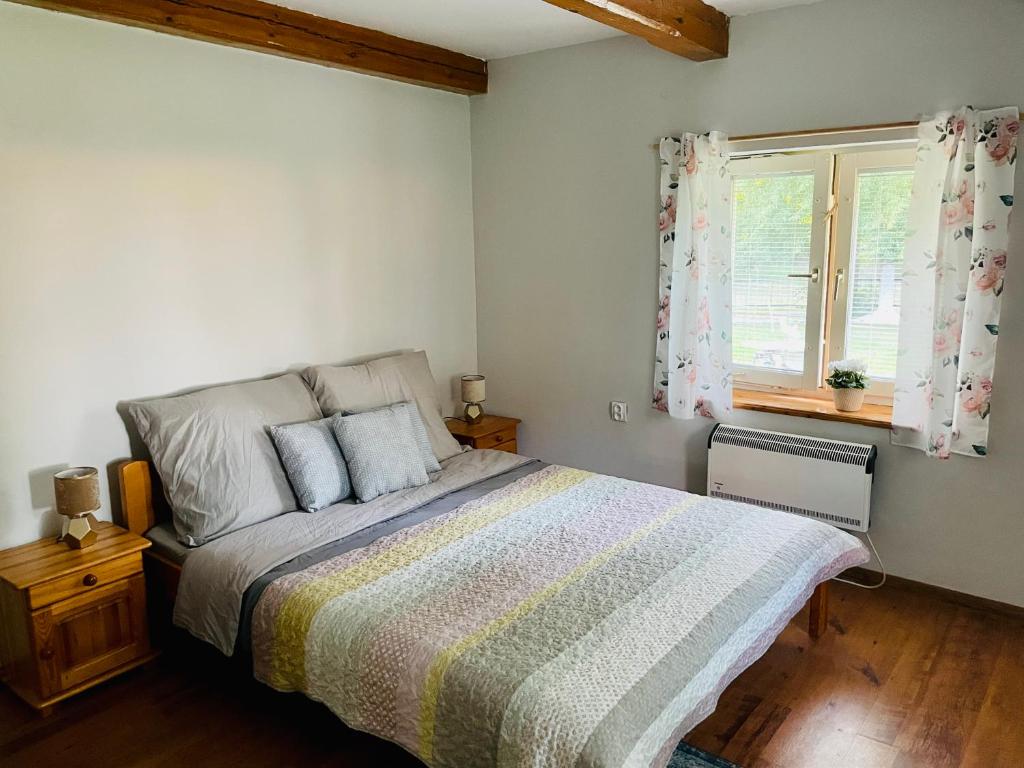 Un dormitorio con una cama grande y una ventana en Domek na farmie, en Sztum