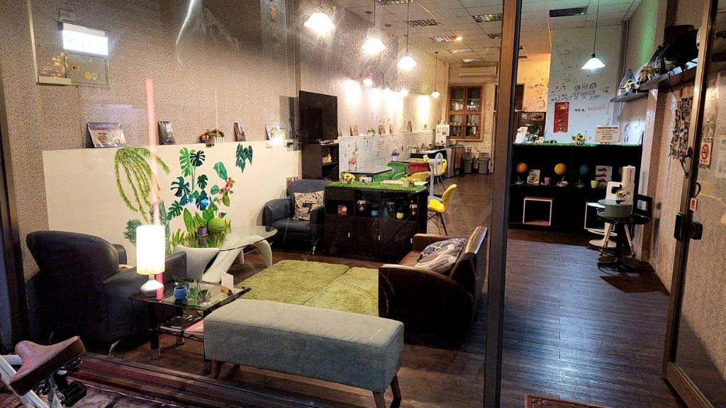 una habitación con sofás y sillas en una tienda en 花蓮阿羅國際青年旅舍民宿, en Hualien City