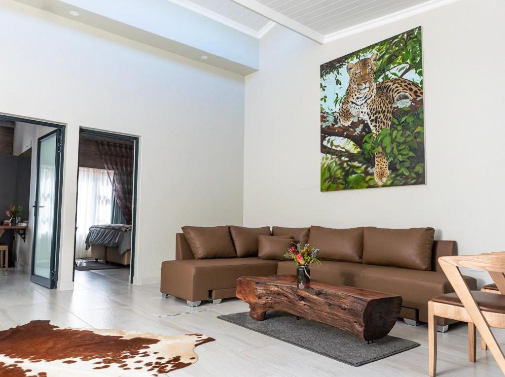 ein Wohnzimmer mit einem Sofa und einem Couchtisch aus Holz in der Unterkunft The Hank Maribashoek Adventure Lodge in Mokopane