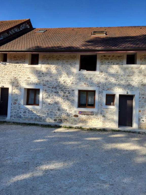 ein Steingebäude mit Fenstern und einem Dach in der Unterkunft le gîte de la Ferme in Belley