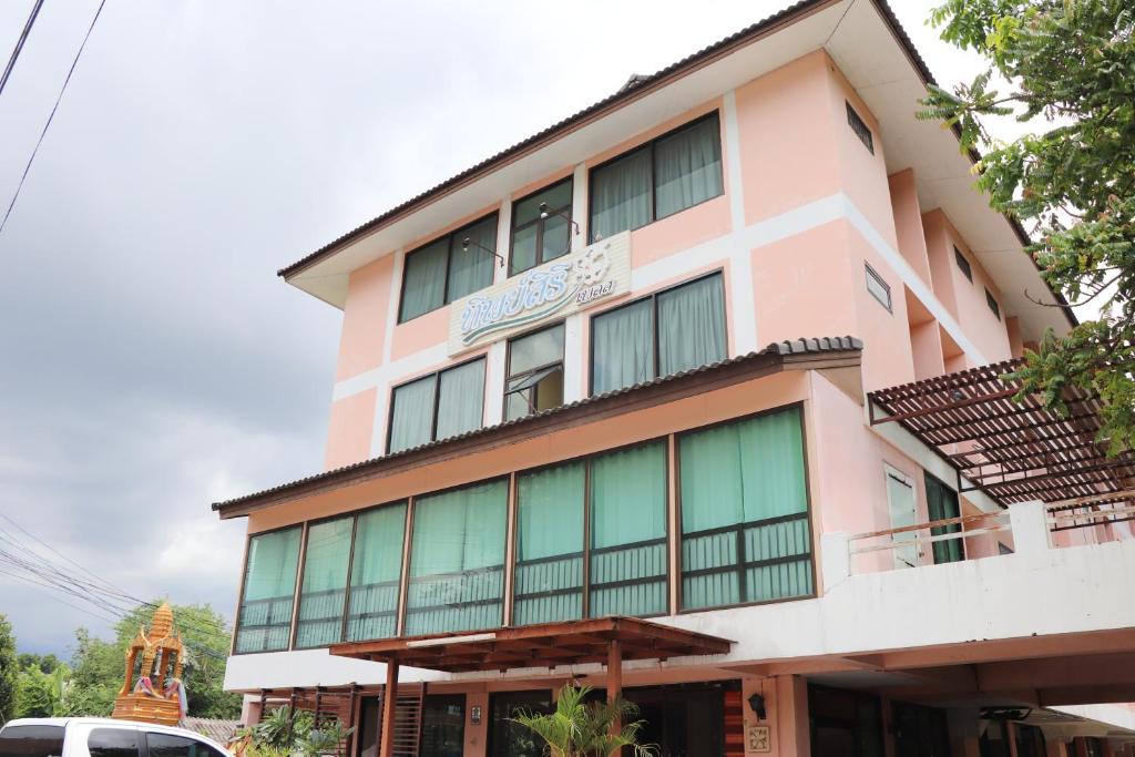 a pink building with a sign on it at OYO 75408 Tipsiri Place in Chiang Mai