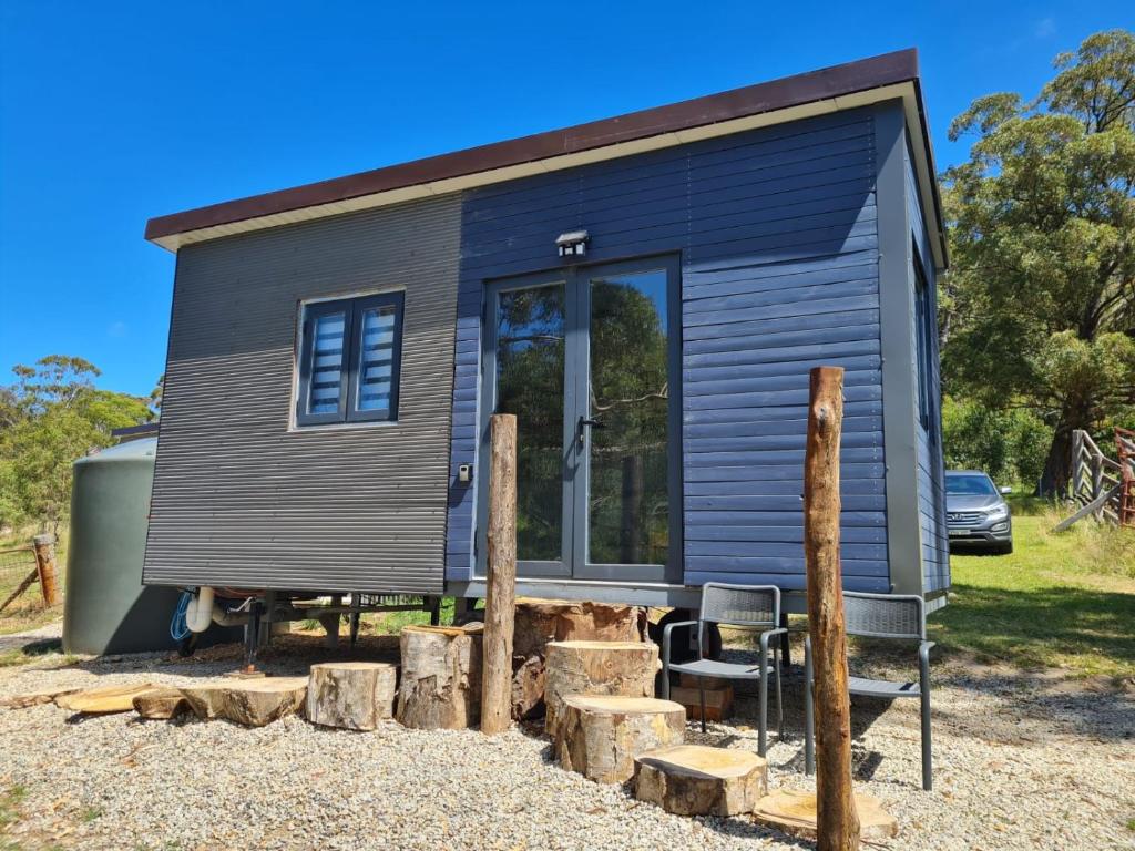 ein winziges Haus auf einem Haufen Holz in der Unterkunft Tiny Home - Bluebird in Hartley