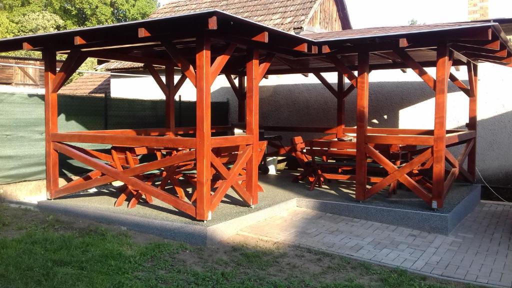 a wooden gazebo with a table and benches at Apartman Silver in Zádiel