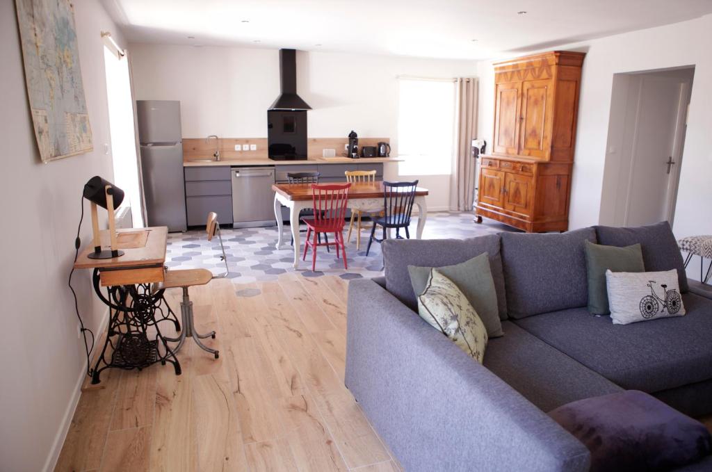 sala de estar con sofá azul y cocina en Le petit Loré, en Sainte-Suzanne
