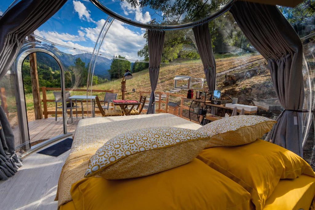 - une chambre dans un dôme avec un lit et une vue dans l'établissement bulle de nuit, à La Ferrière