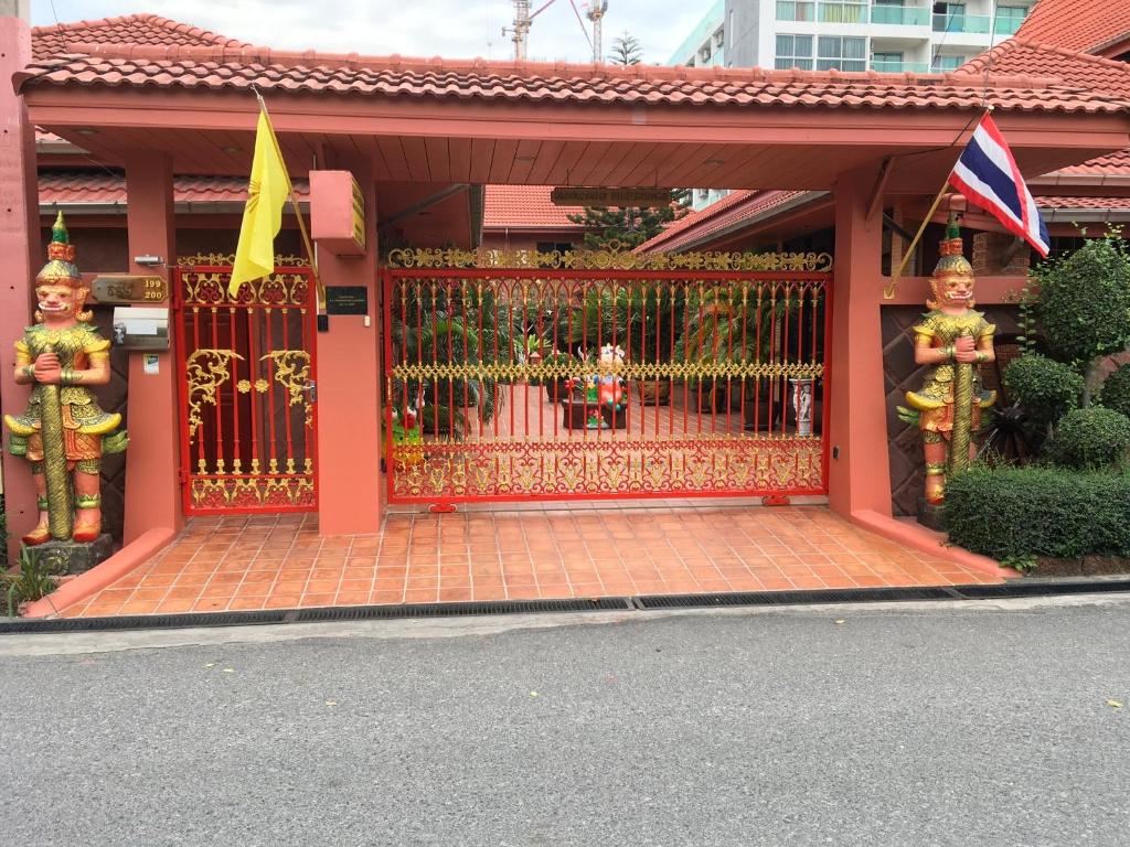 una puerta a una casa con una bandera y estatuas en Magadan Residence, en Pattaya South