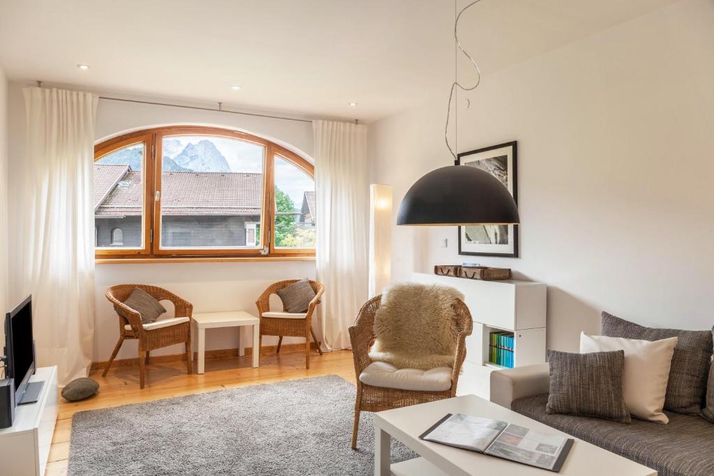 uma sala de estar com um sofá e uma mesa em Fewo im Blauen Haus Dg em Garmisch-Partenkirchen
