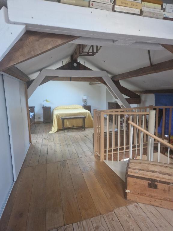 a bedroom with a bed in a room with wooden floors at La maison du vigneron in Auzon