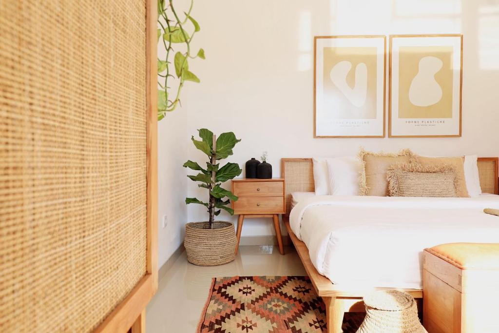 a bedroom with a bed and a potted plant at Beautiful Tropical-Boho 3BR Villa, Berawa Canggu, Bali in Canggu