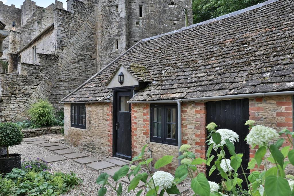 a small brick building with a window and a roof at The Bothy Beverston Castle in Tetbury