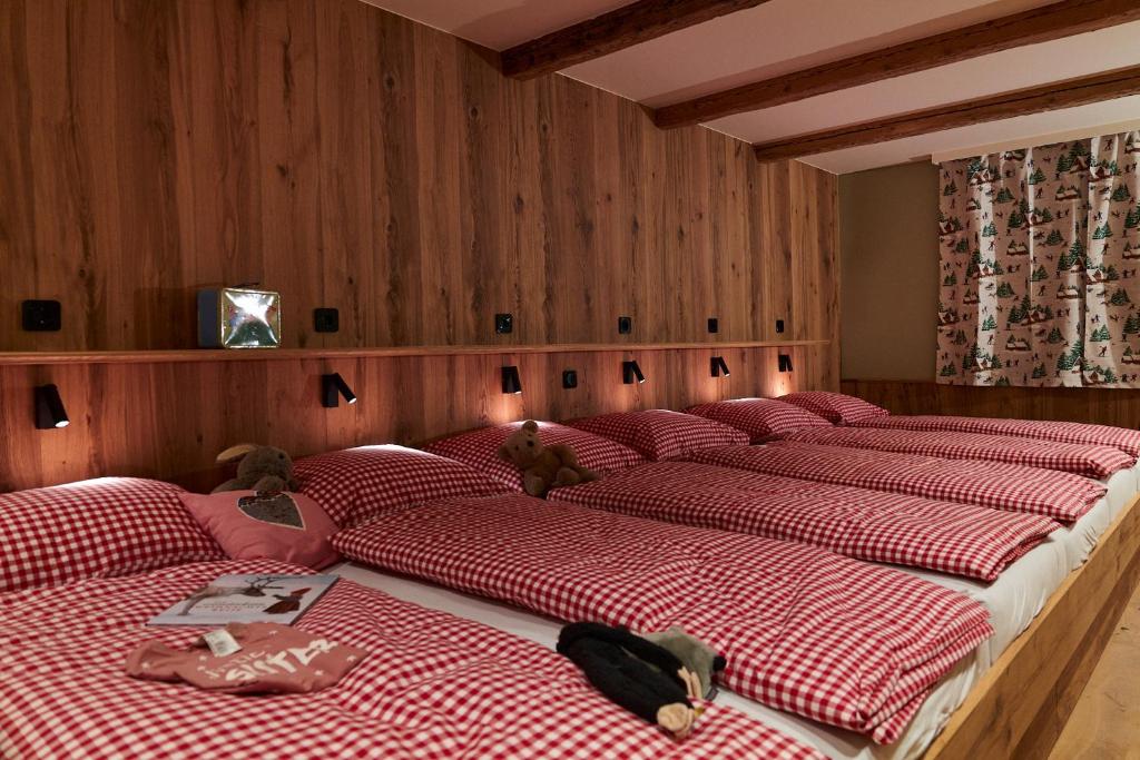 a row of four beds in a room at Berghaus Schröcken - Hotel Apartments Spa in Schröcken