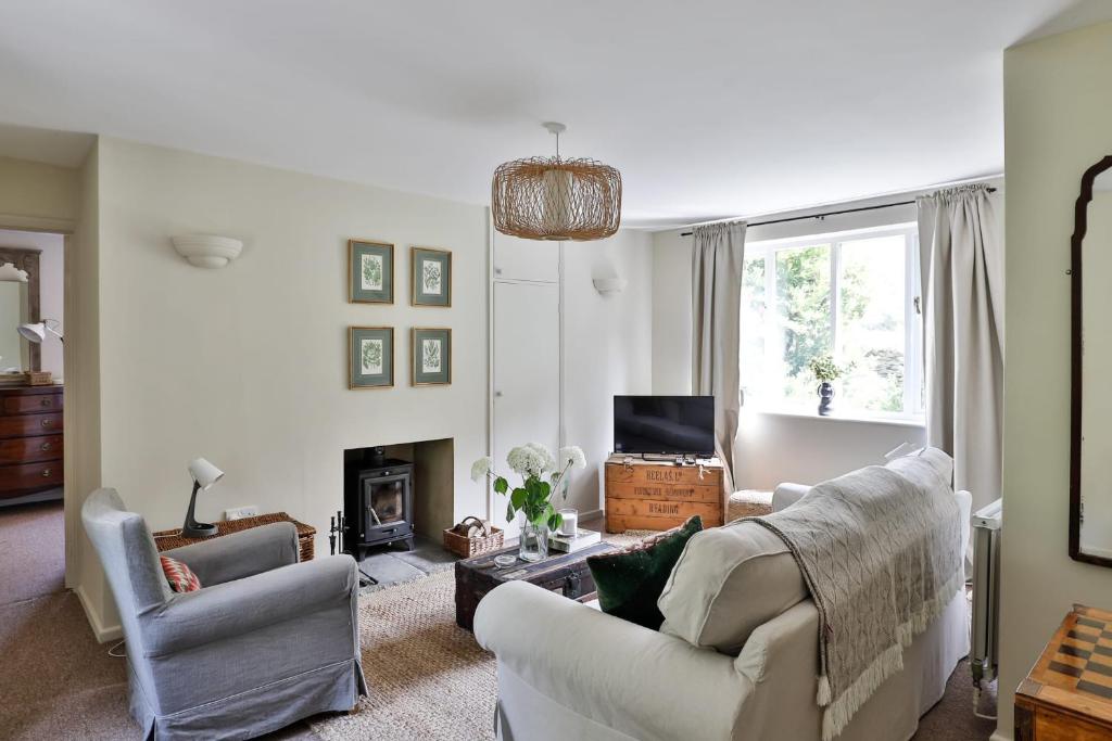 a living room with two couches and a fireplace at The Butlers Bungalow Beverston Castle in Tetbury