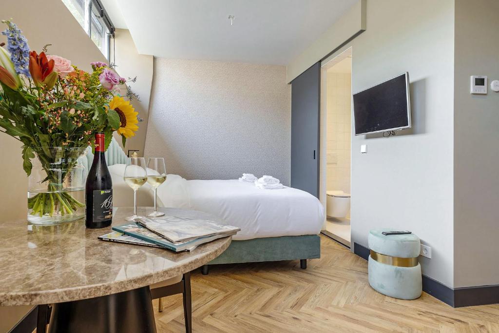 Una habitación de hotel con una cama y una mesa con flores. en Bens The Walton, en Ámsterdam