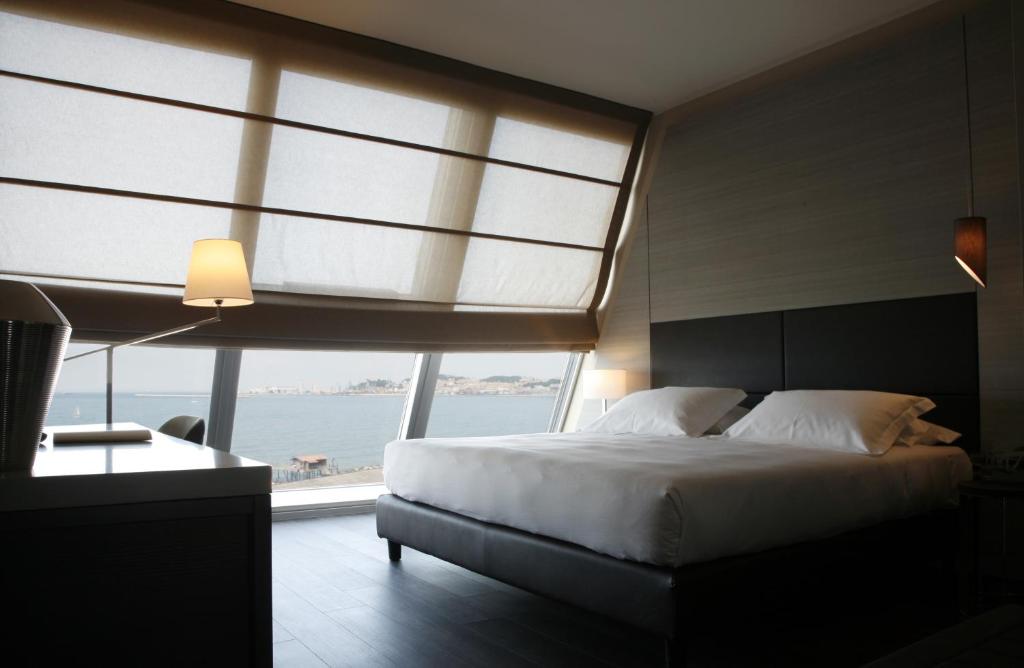 a bedroom with a large bed and a large window at Ego Hotel in Ancona
