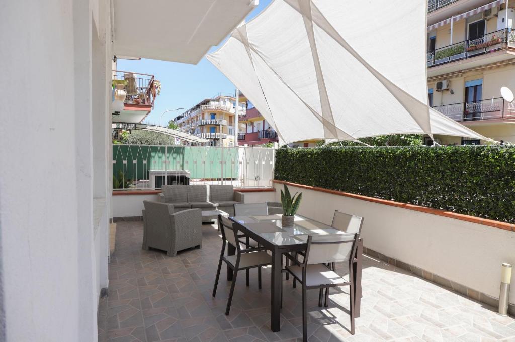 patio ze stołem i krzesłami na balkonie w obiekcie Casa Costanzo w mieście Capaci