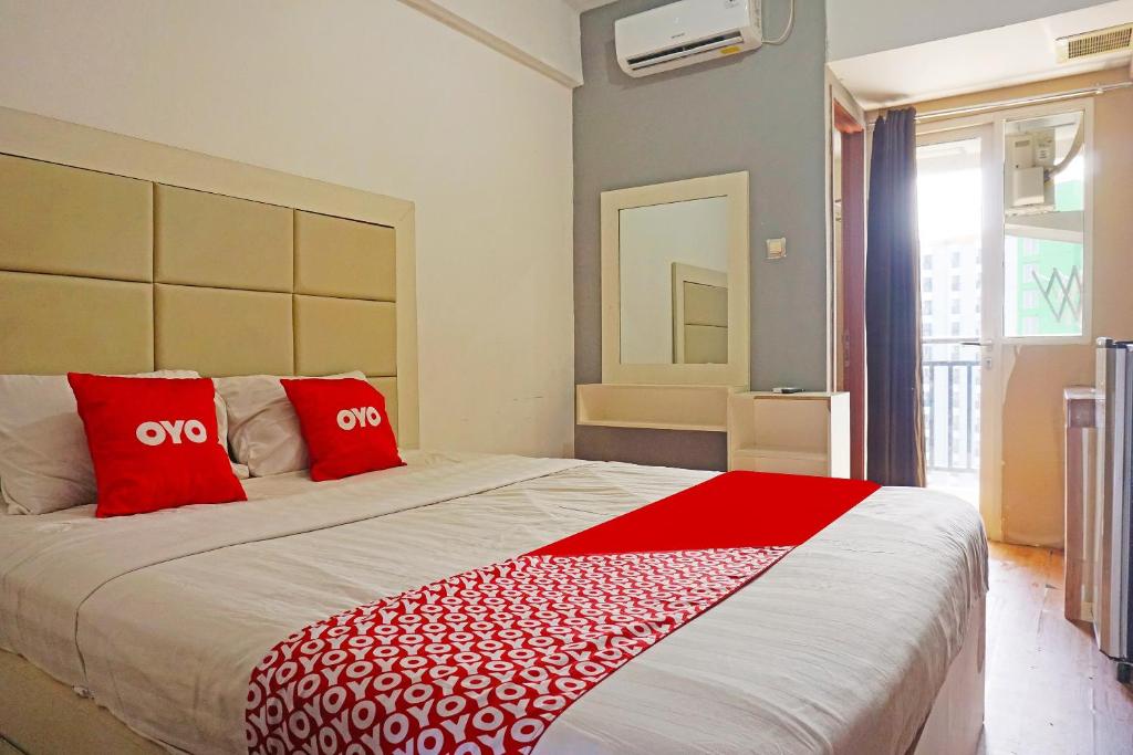 ein Schlafzimmer mit einem großen Bett mit roten Kissen in der Unterkunft Collection O GLV Tower B in Tangerang