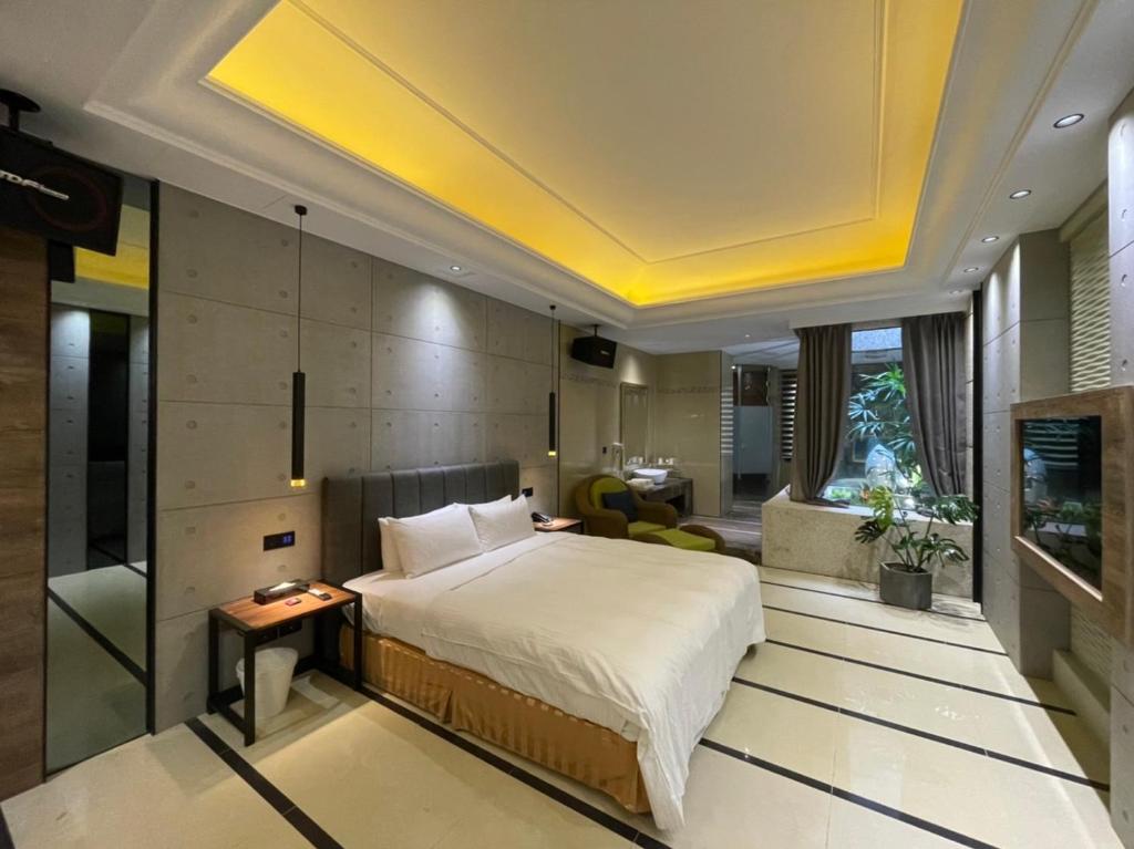 um quarto com uma cama grande e um tecto amarelo em Minimalist Fashion Motel em Taoyuan