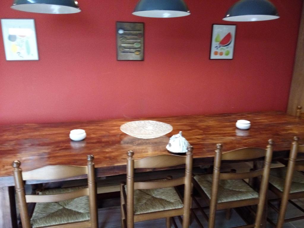 drewniany stół w pokoju z czerwoną ścianą w obiekcie LA NURSERY DE MAS GUILLO w mieście San Quintín de Mediona