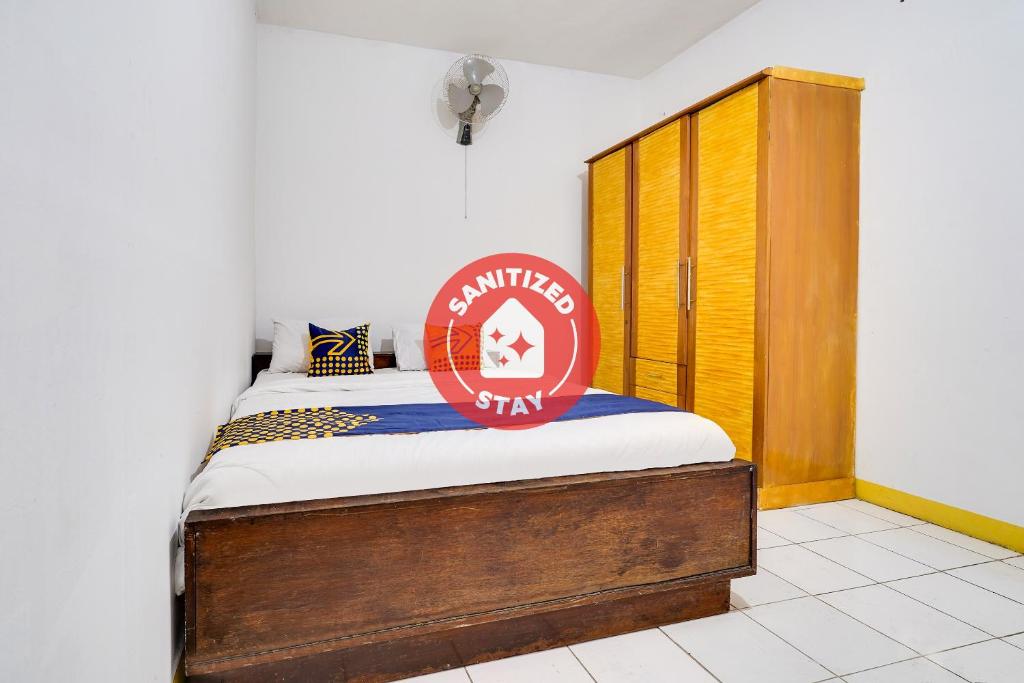 Bett mit Schild auf einem Zimmer in der Unterkunft OYO 91546 Dewi Sudirman Homestay in Bandung