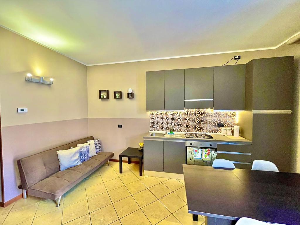 a living room with a couch and a kitchen at CASA DI MIRCO - AMPIO E MODERNO BILOCALE in Castenedolo