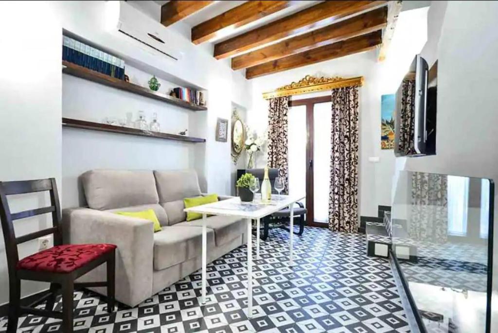 ein Wohnzimmer mit einem Sofa und einem Tisch in der Unterkunft Typical Sevillan 2 bedroom unit in Sevilla
