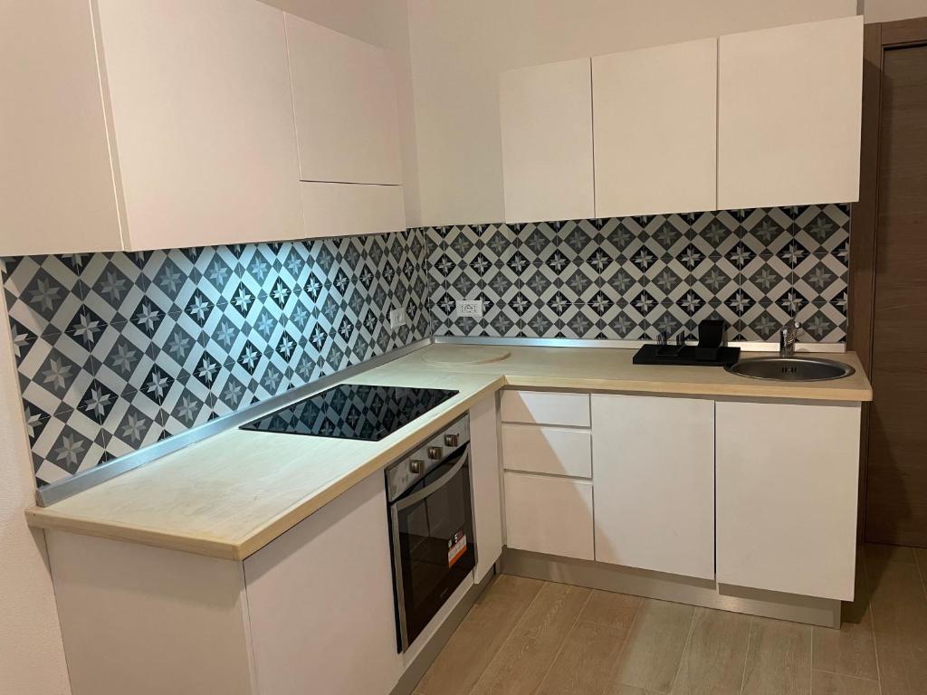a kitchen with white cabinets and black and white tiles at Cà di GIACO in Moneglia