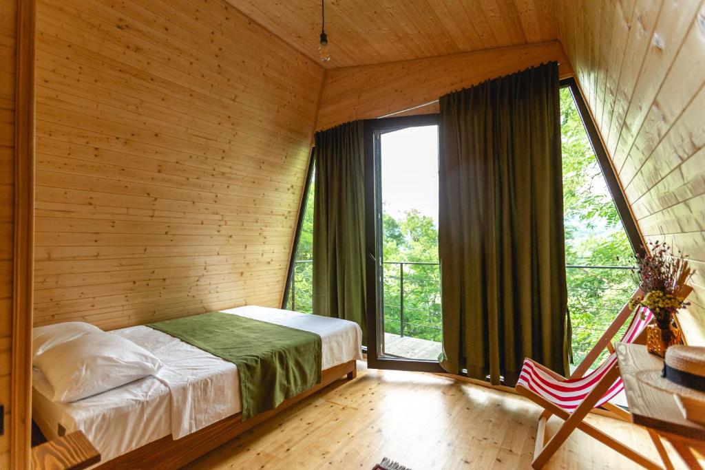 a bedroom with a bed and a large window at Porto Gumati in Kutaisi