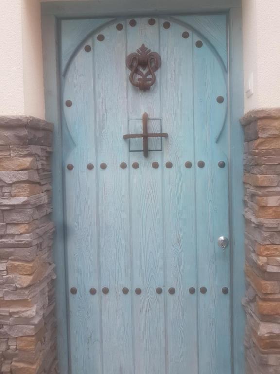 Una porta blu con una croce sopra. di Casa Azul de la Almedina de Almería a Almería