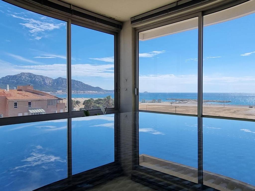 Cette chambre dispose de fenêtres offrant une vue sur l'océan. dans l'établissement Spacieux appartement vue mer panoramique & parking, à Marseille