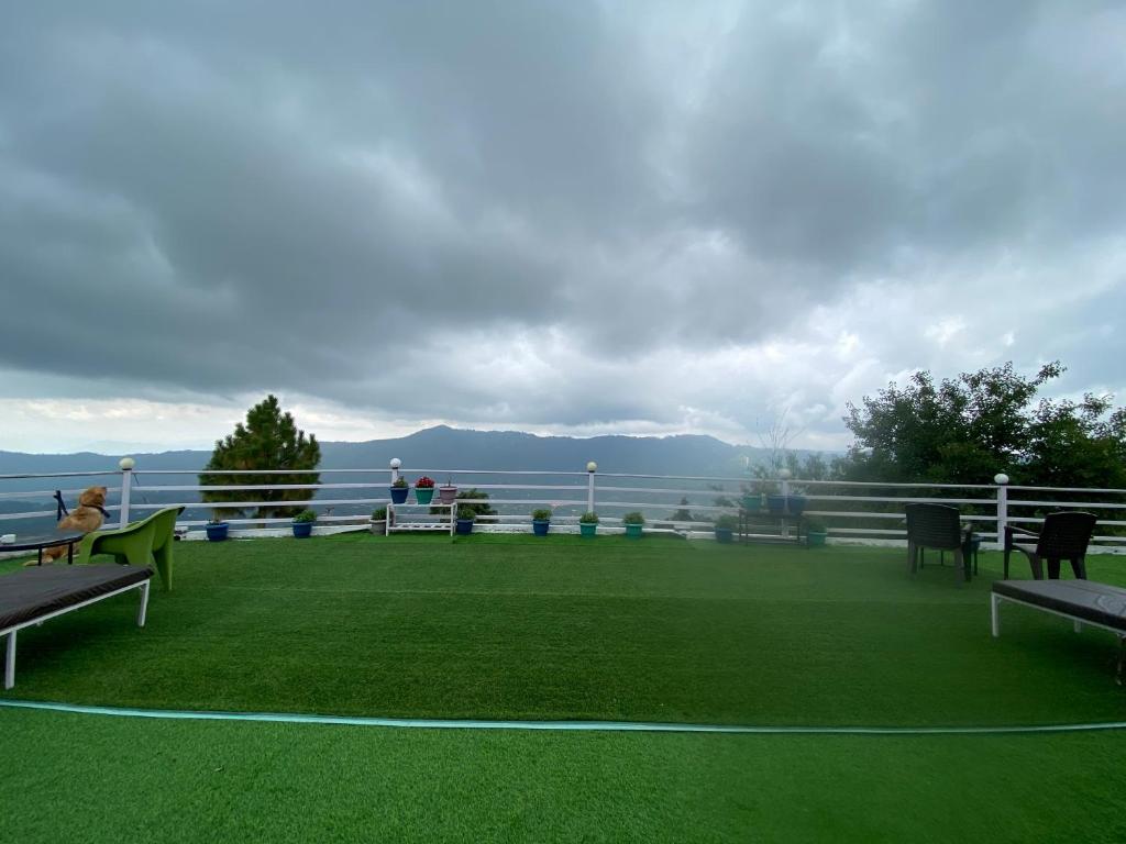 a balcony with benches and a view of the water at Wincliff Orchard Resort in Mukteshwar