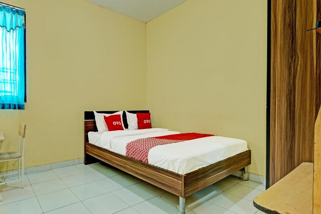 Un dormitorio con una cama con almohadas rojas. en OYO 91532 Malioboro Guesthouse, en Yogyakarta