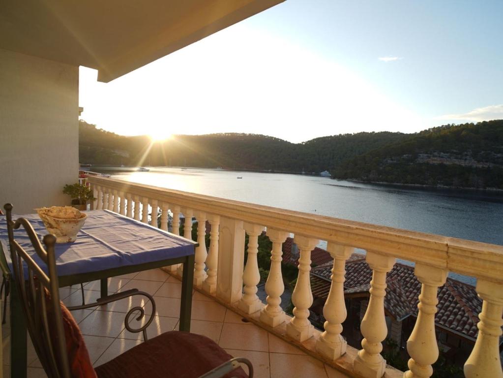 a balcony with a table and a view of the water at Sea House Mljet in Polače