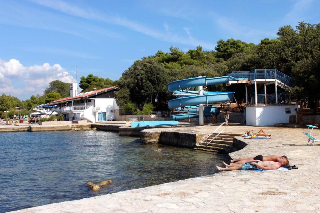 mężczyzna leżący na plaży obok parku wodnego w obiekcie Studio Vrsar 17473a w mieście Vrsar